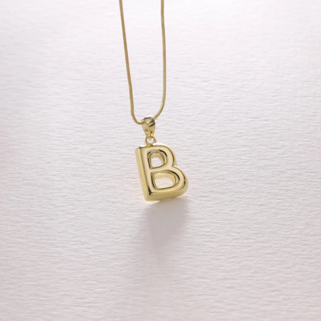 Bubble letter necklace in gold styled with a casual outfit