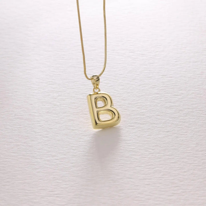 Bubble letter necklace in gold styled with a casual outfit