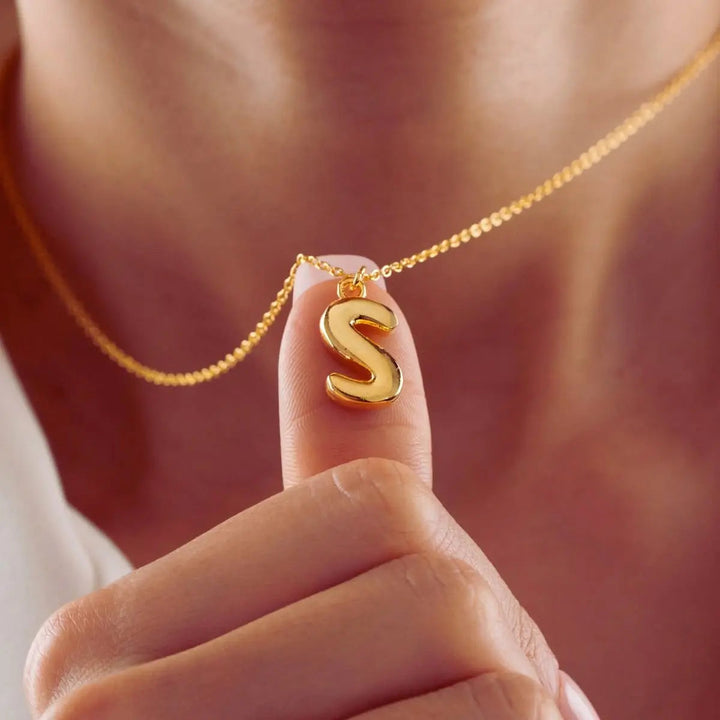 Bubble letter necklace styled on a neck