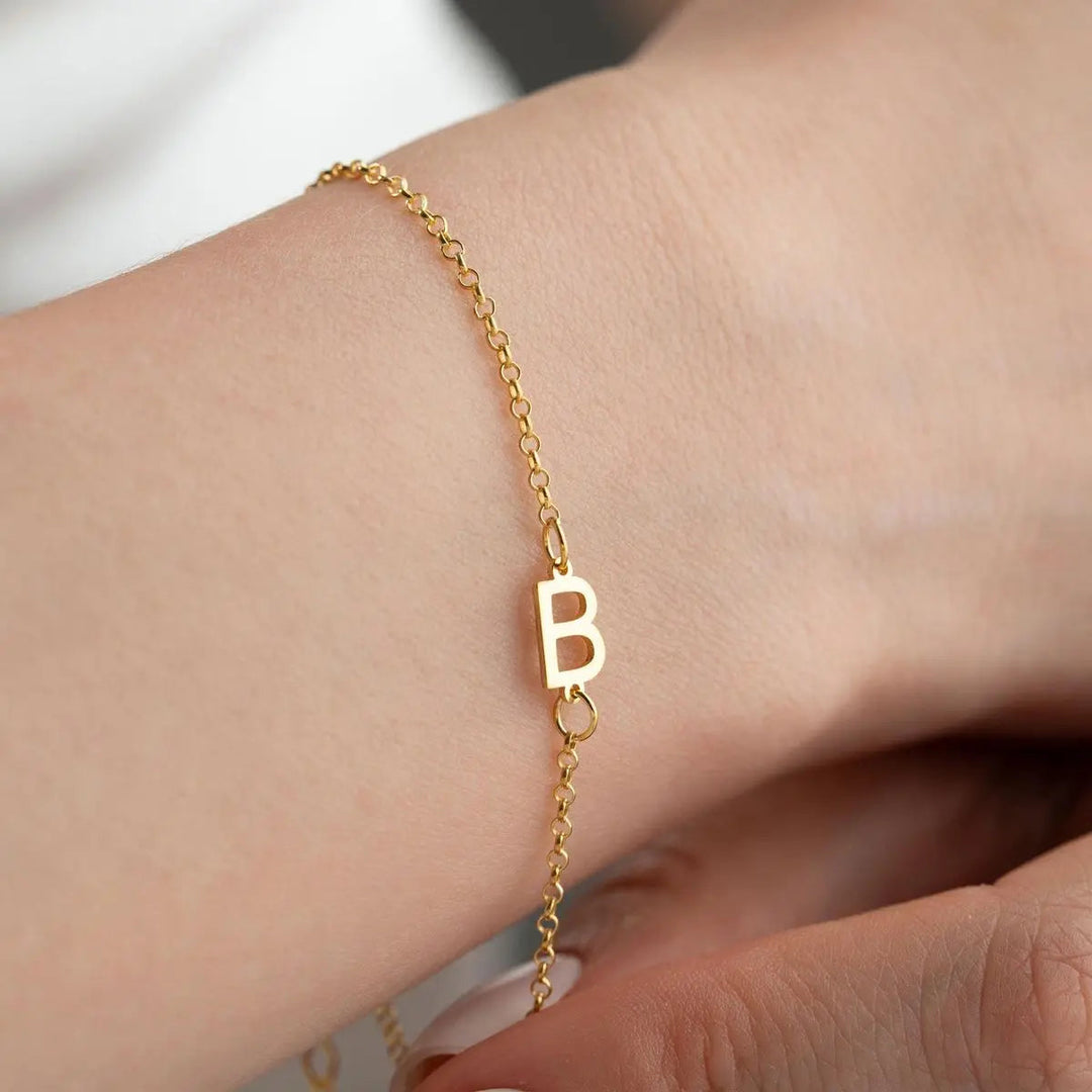 Multiple sideways initial bracelets stacked