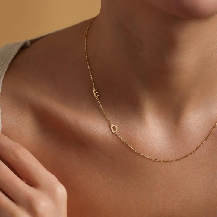 Sideways initial necklace styled on a neck