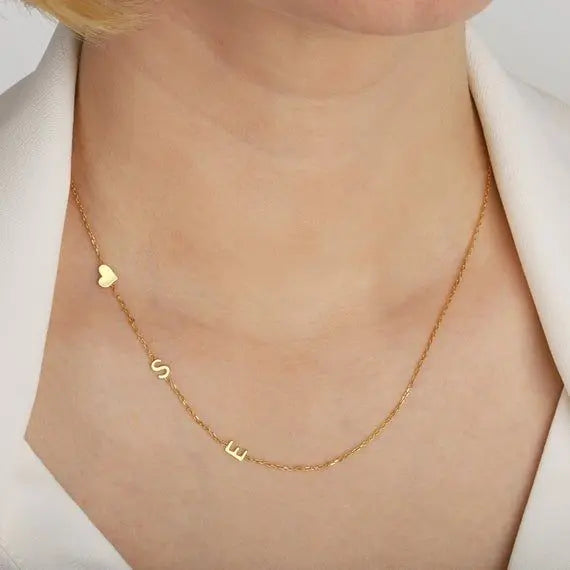 Close-up of engraved sideways letter pendant on dainty chain