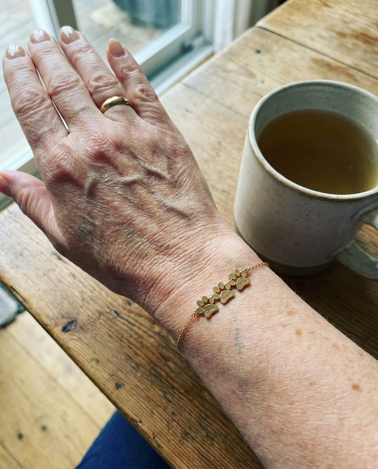 Customer wearing the Custom Paw Name Bracelet in gold