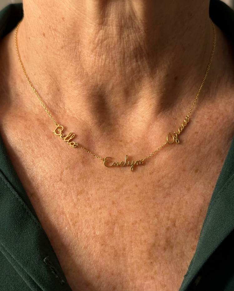 Customer wearing a three-name necklace in gold