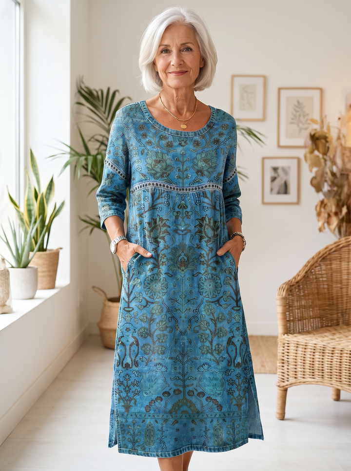 Older woman wearing the Carmen blue printed dress, hands in the side pockets