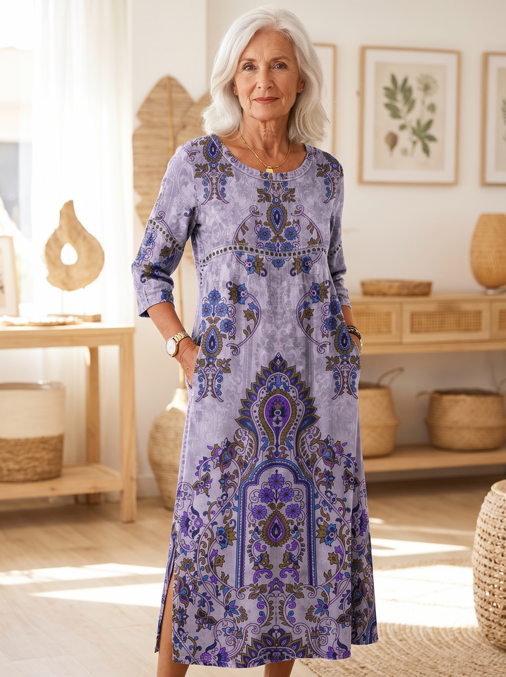 Older woman wearing the Petra printed dress, hands in the side pockets