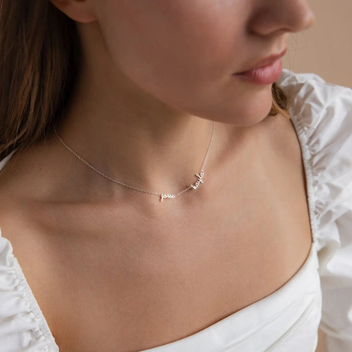 Woman wearing a dainty multiple name necklace